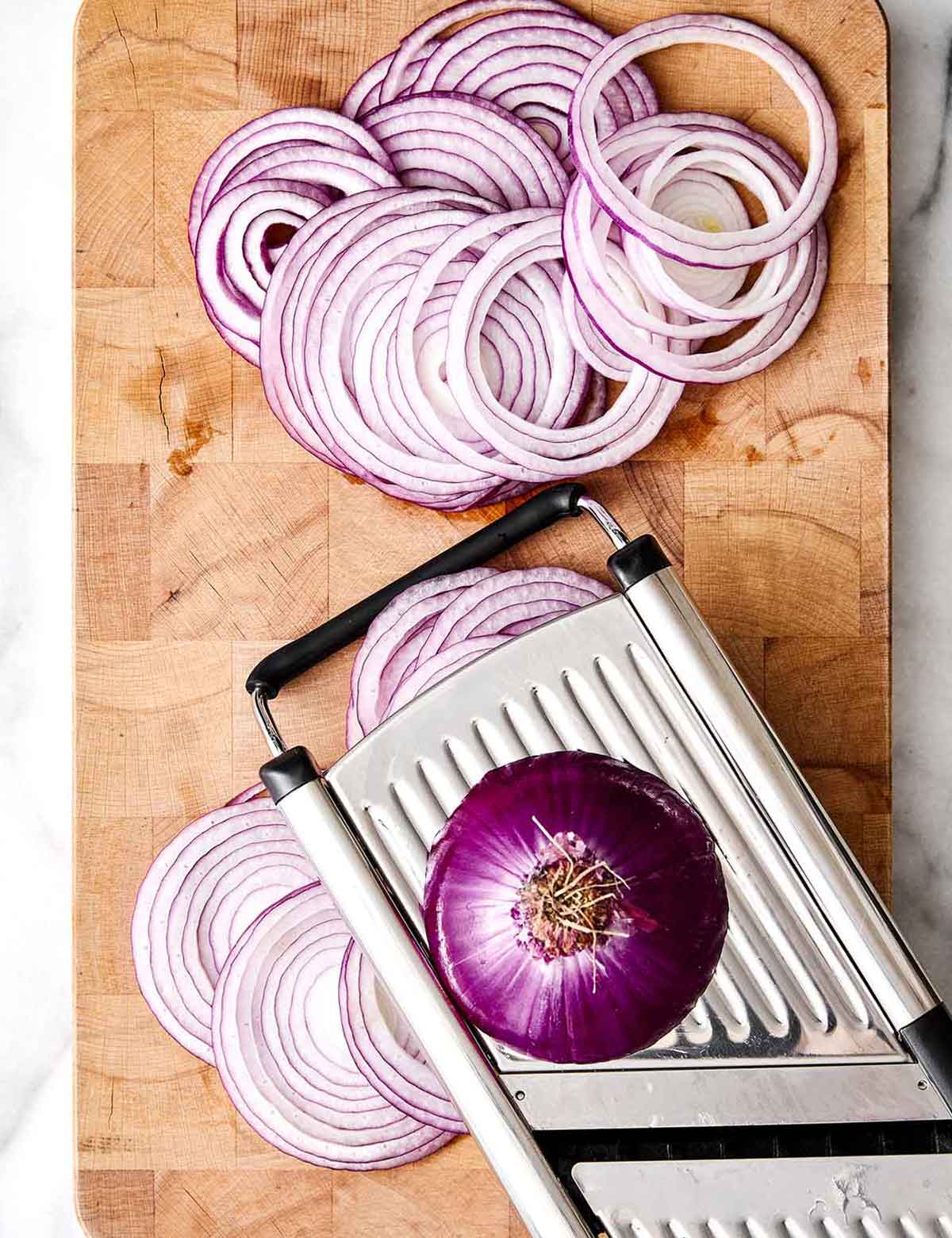 Slicing red onions with a mandoline.