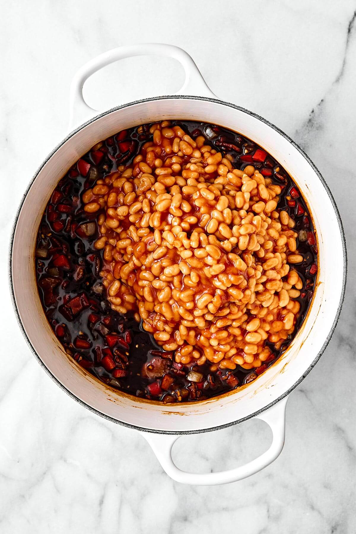 Mixing baked beans in a pot.