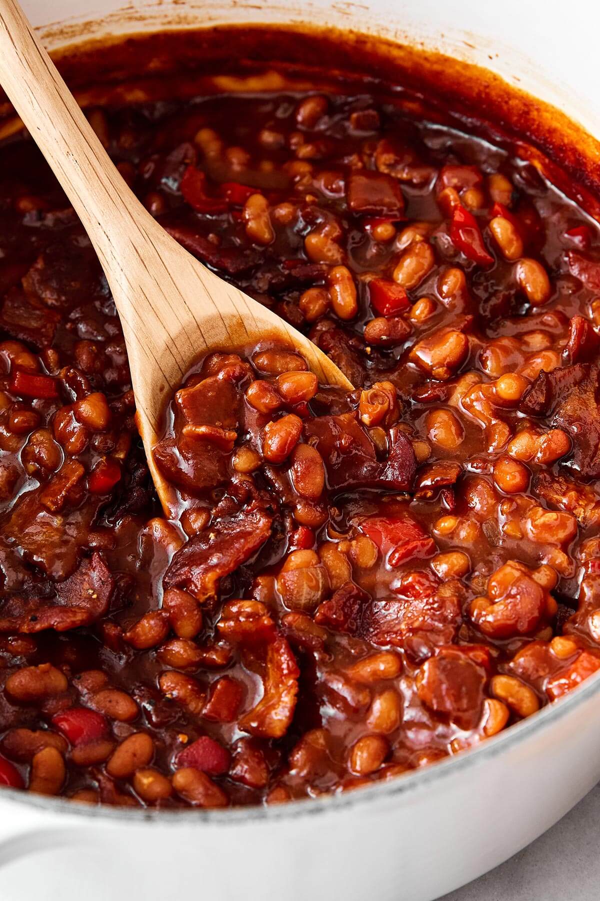 A pot of baked beans and a spoon.