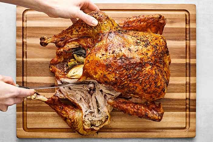 Step one of how to carve a turkey: remove the legs and thigh.