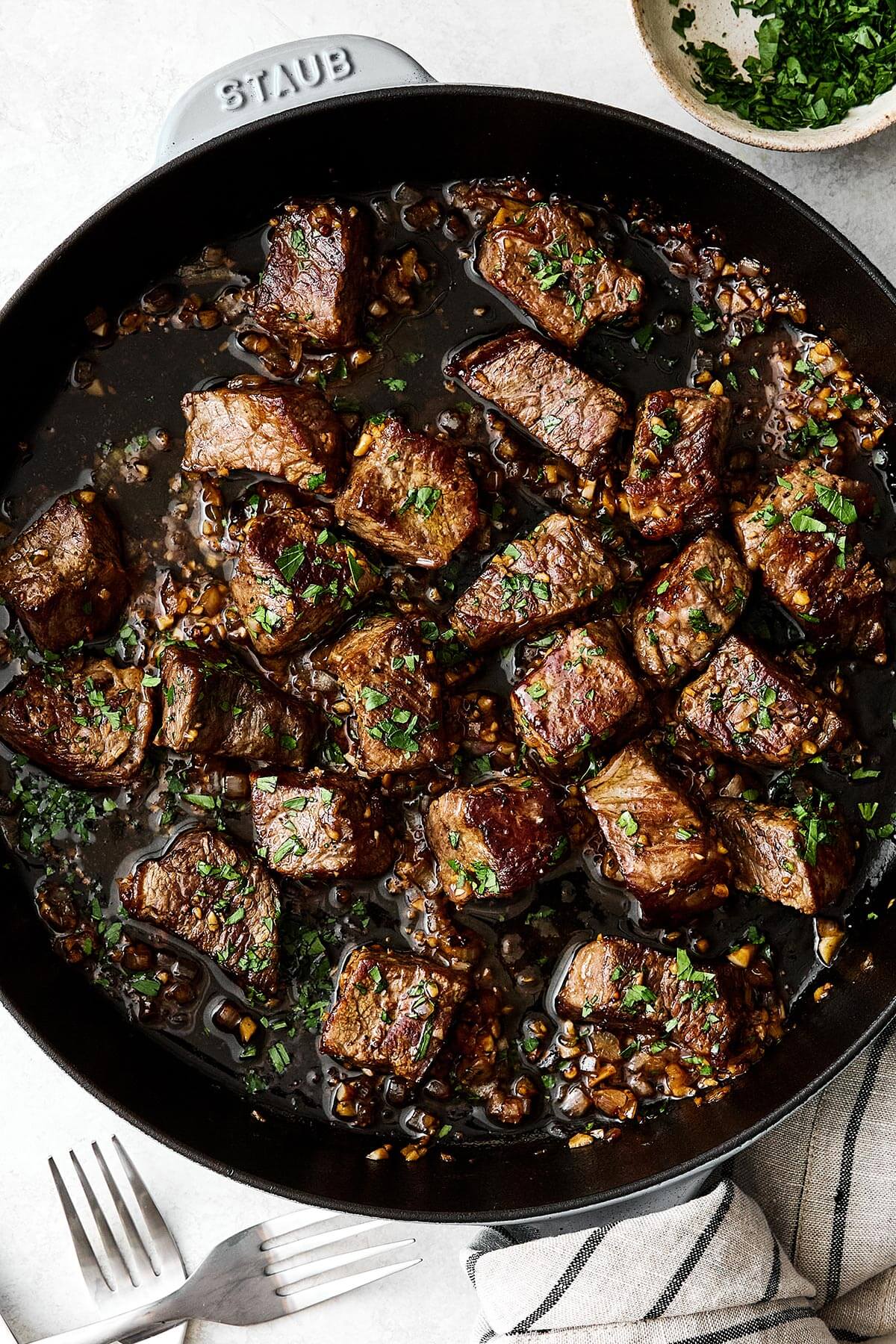 A skillet with garlic butter steak bites.