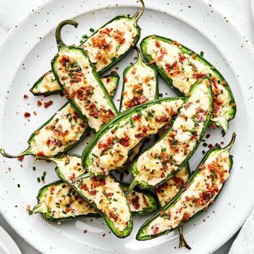 A white plate of jalapeño poppers.