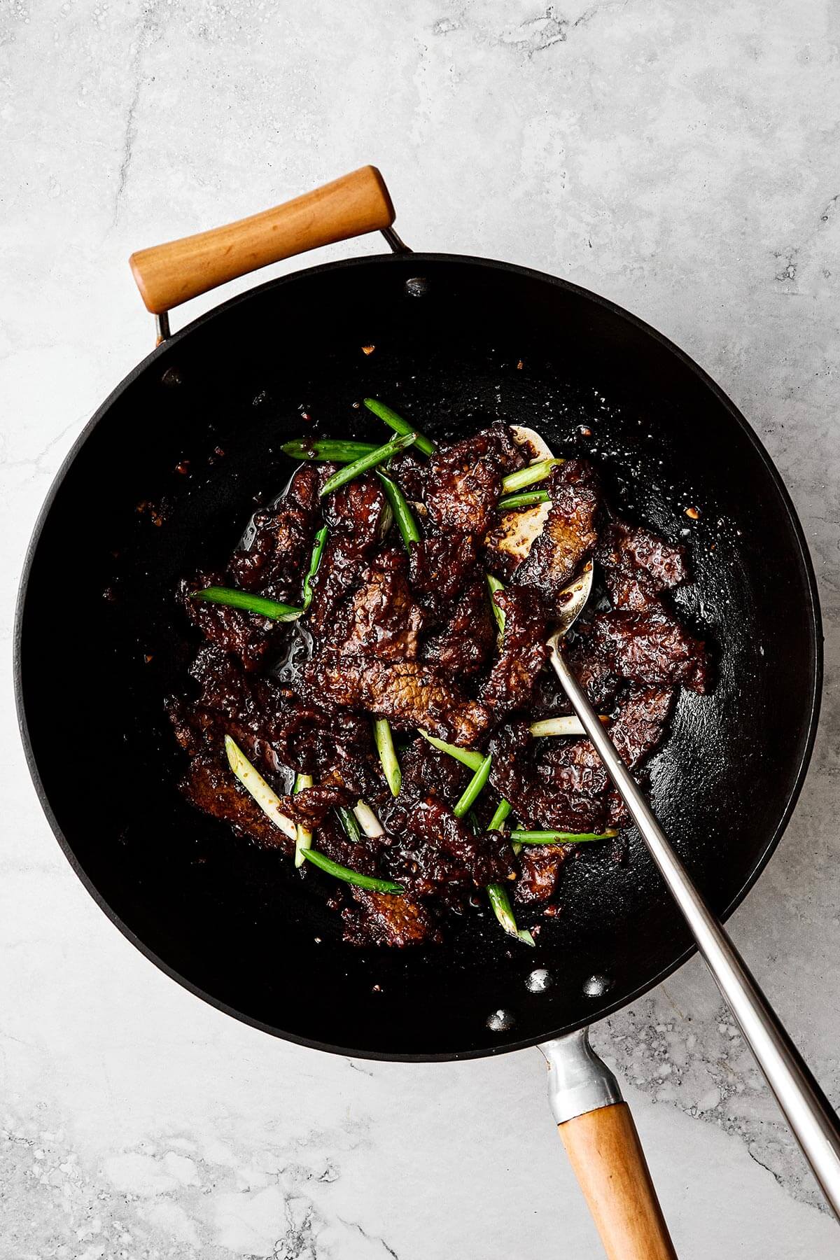 Cooked Mongolian beef in a wok.