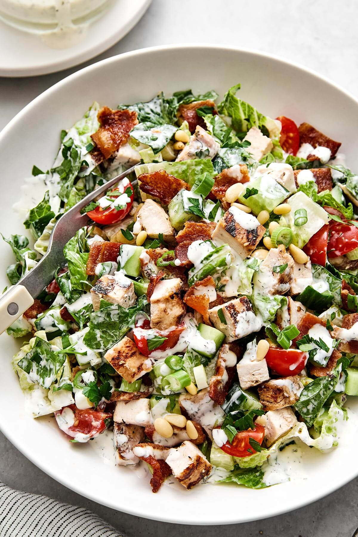 A white bowl of chicken bacon ranch chopped salad.