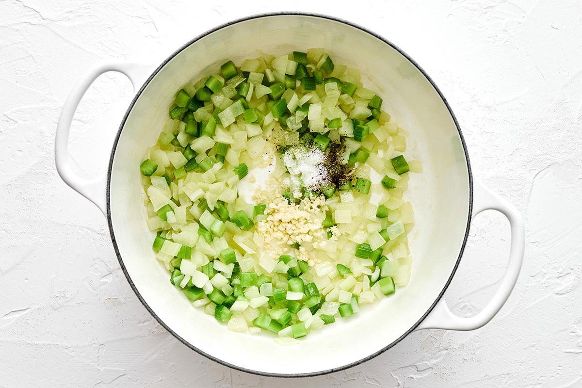 Cooking onions and bell pepper in a pot.