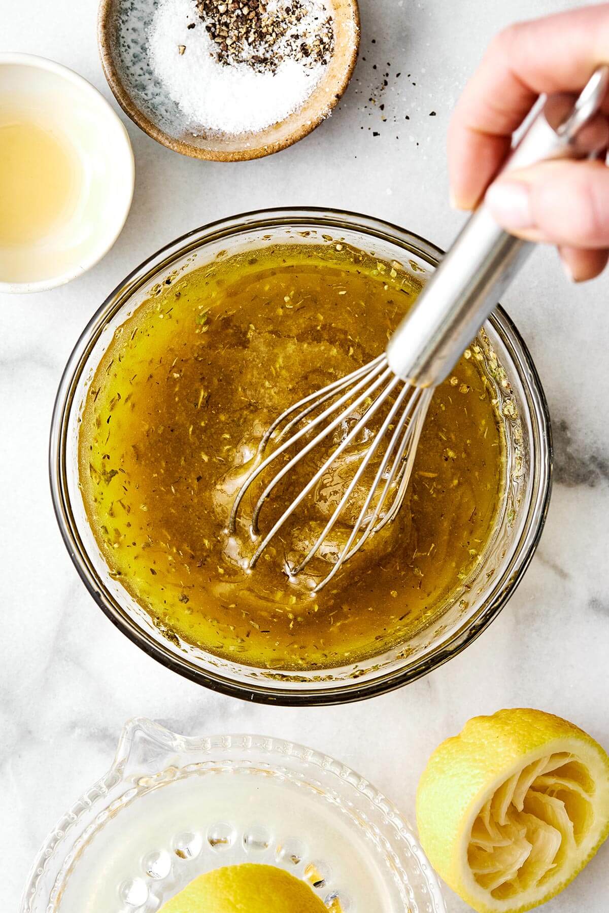 Whisking Italian dressing in a bowl.
