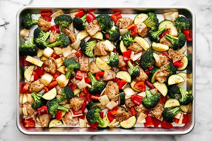A sheet pan filled with diced chicken and veggies.