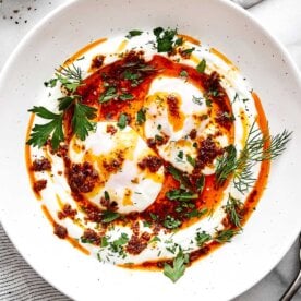 A plate of Turkish eggs with garlic yogurt and poached eggs.