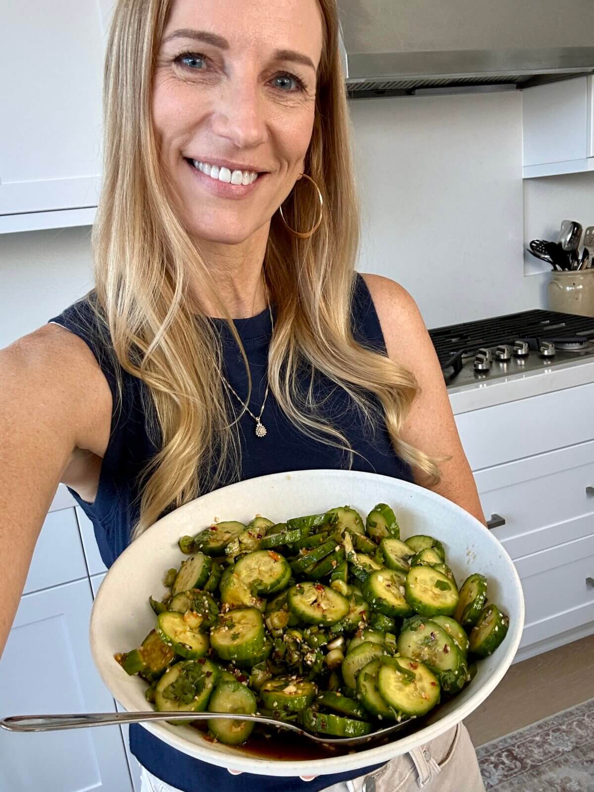 Lisa enjoying the Asian cucumber salad in a bowl.