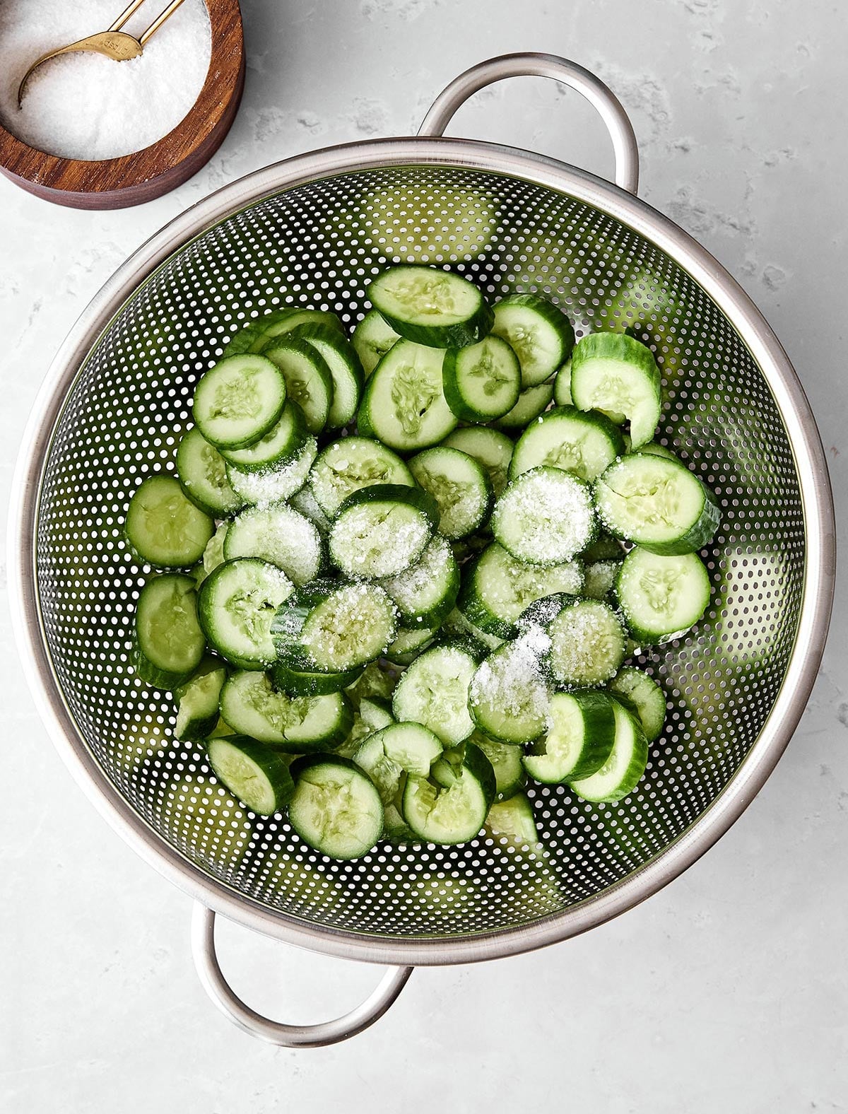 Fresh, crunchy, and packed with flavor, this Asian cucumber salad is the perfect side dish for Asian-inspired dinners! Rinsing cucumbers in colander for salad.