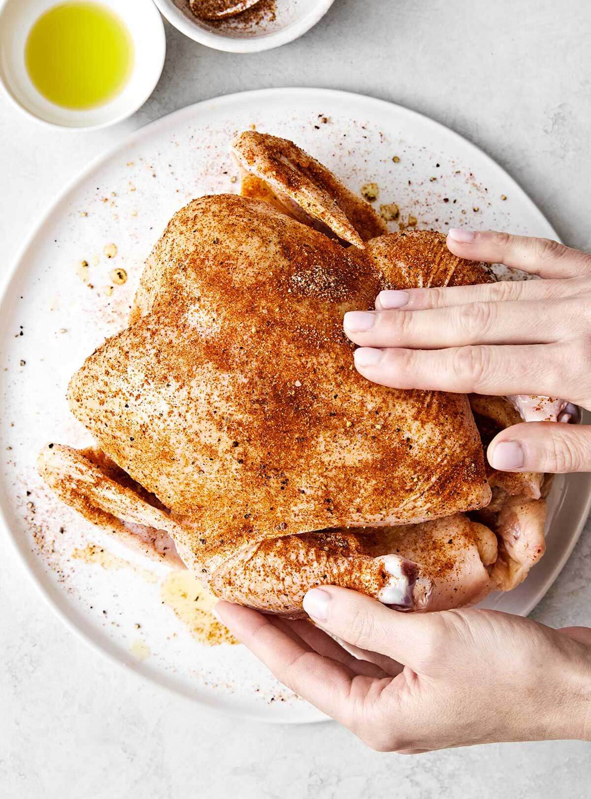 Adding seasoning to chicken.