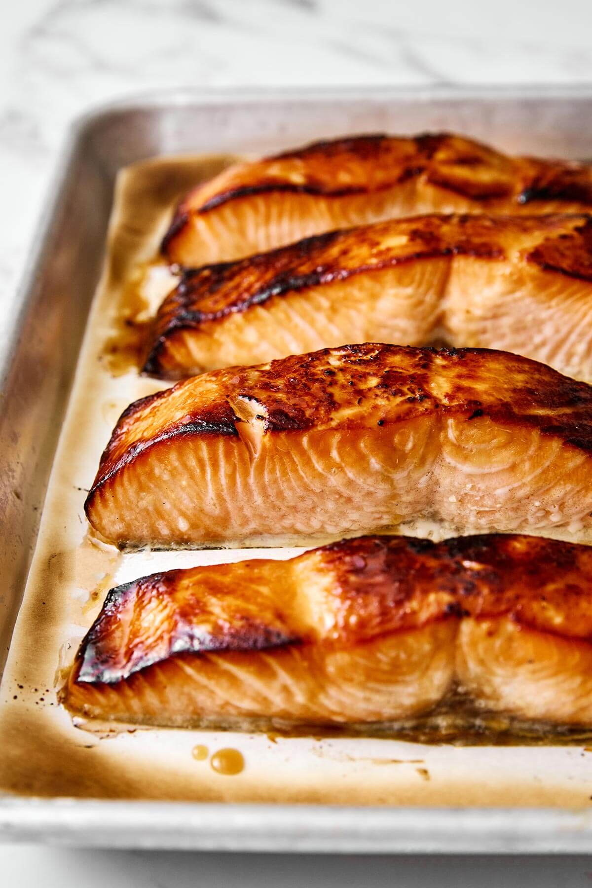 You'll crave this miso salmon time and again! It's incredibly simple, packed with umami flavor, and broiled to perfection in 7 minutes! A sheet pan of miso salmon filets.