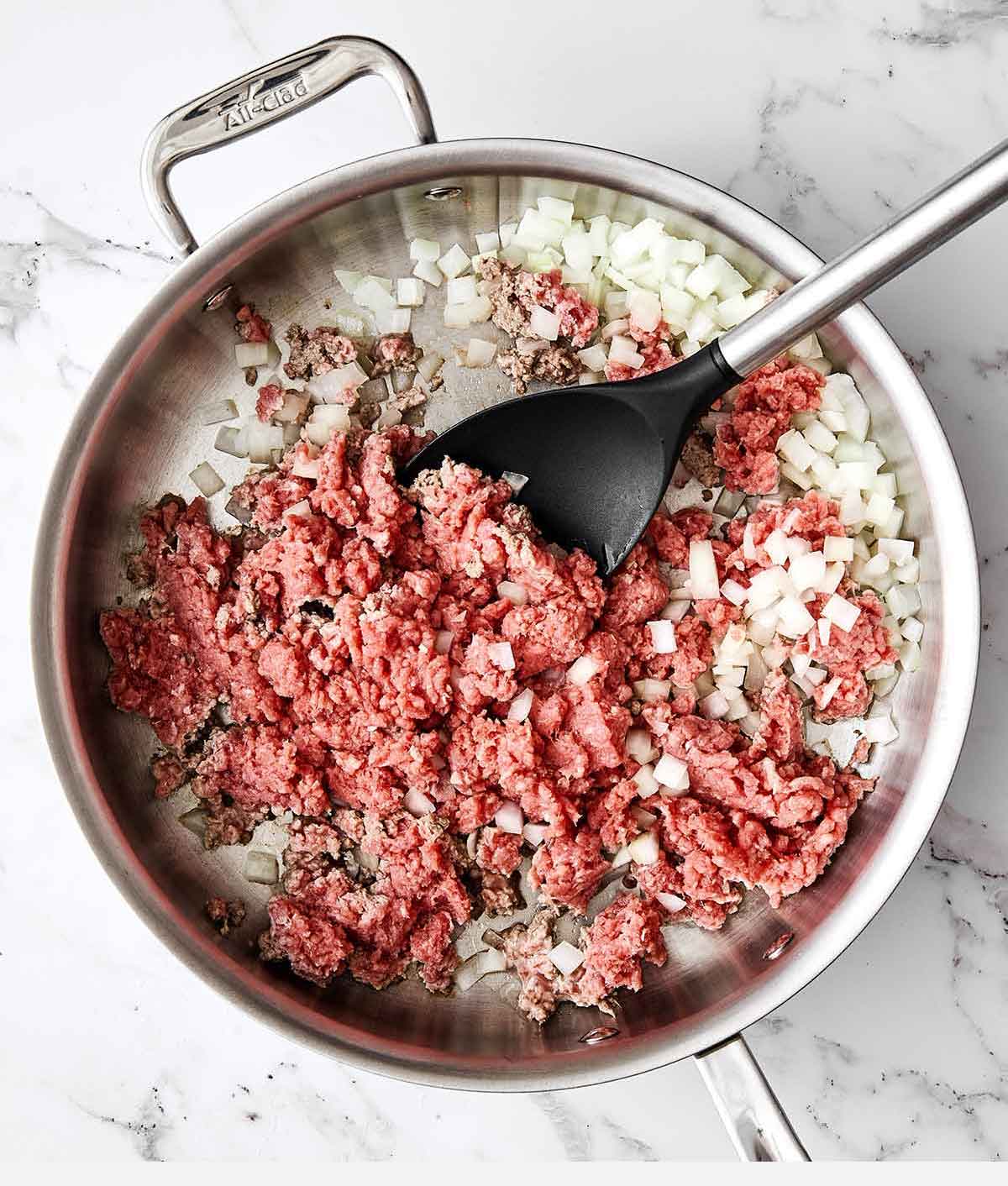 Cooking beef and onions in a pan.
