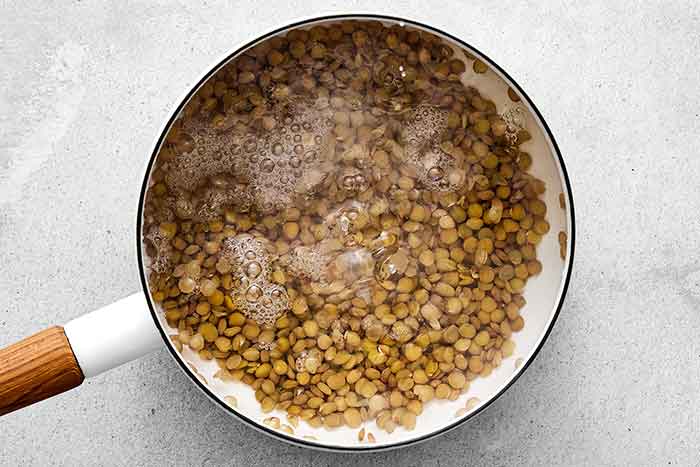 Cooked lentils in a pot for a sweet potato salad.