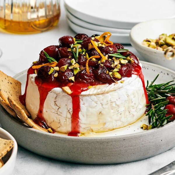 Thanksgiving appetizers featuring a baked brie with cranberry sauce.