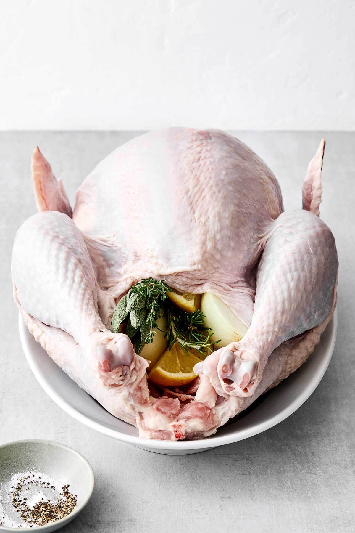 Filling the turkey cavity with herbs and aromatics.