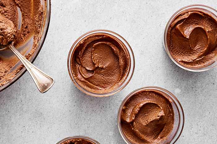 Step four: adding the chocolate mousse to cups.