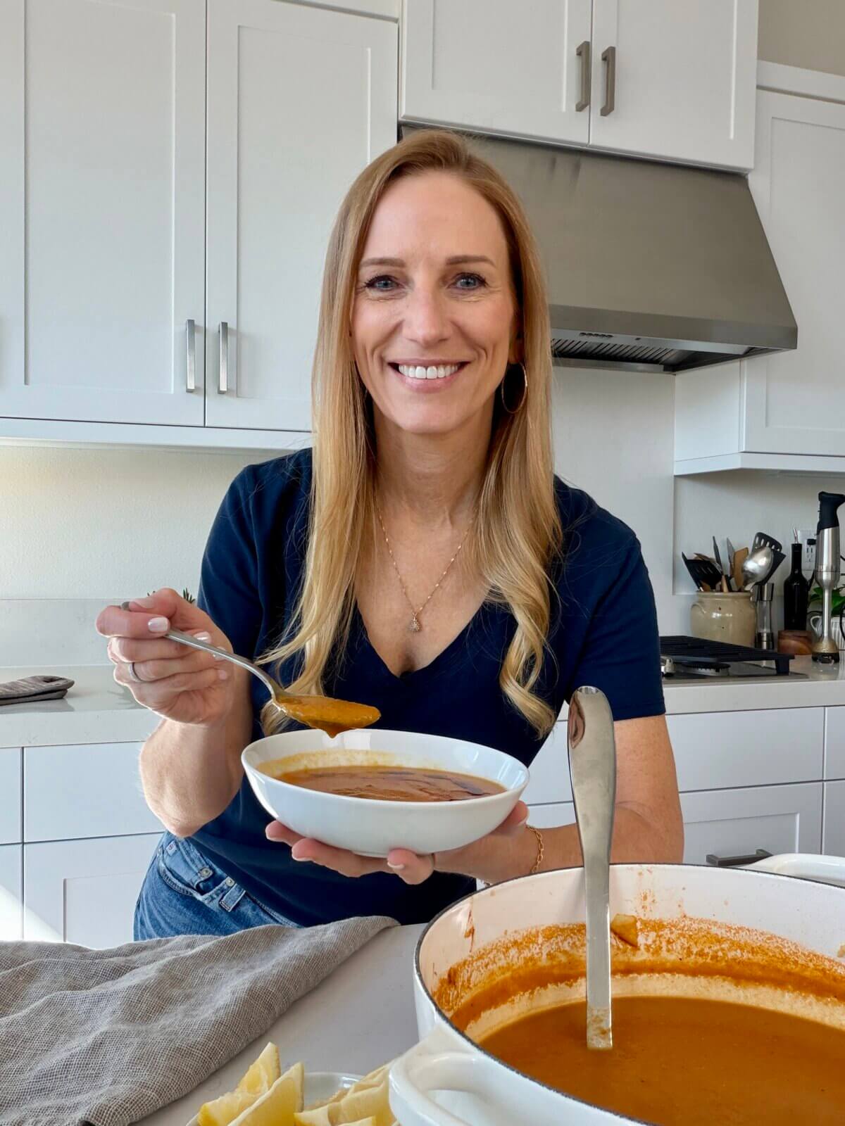 Lisa holding a bowl of red lentil soup.