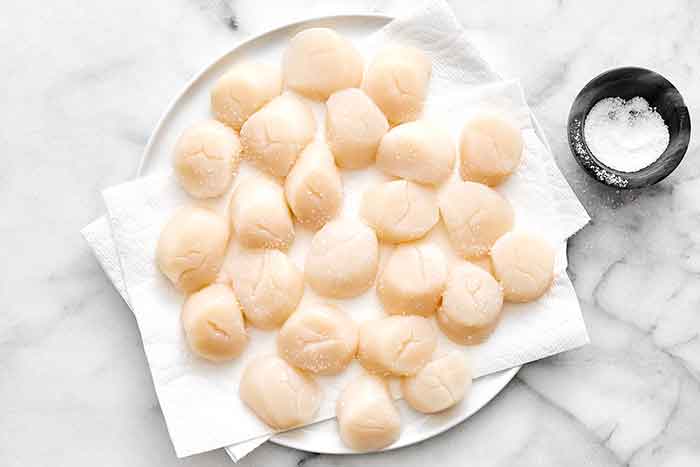 Step one of seared scallops: pat scallops dry.