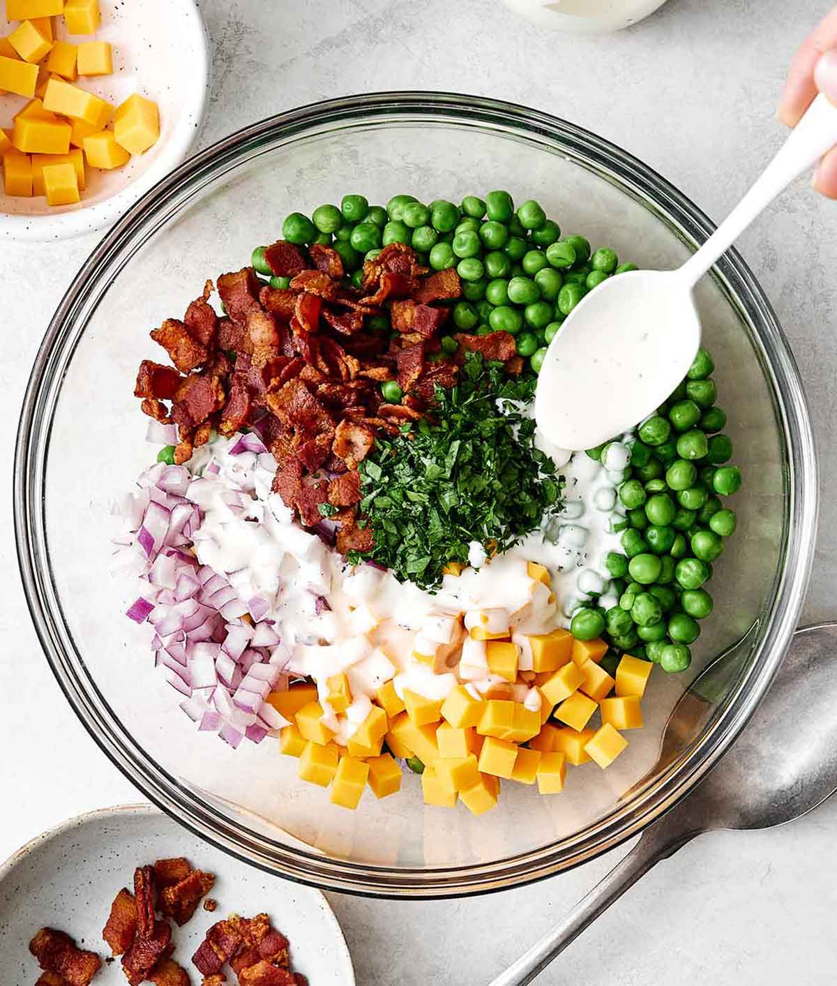 This creamy pea salad has become a spring and summer staple! It's simple, flavorful, and perfect for potlucks and group gatherings. Step three of pea salad: mix it all together.