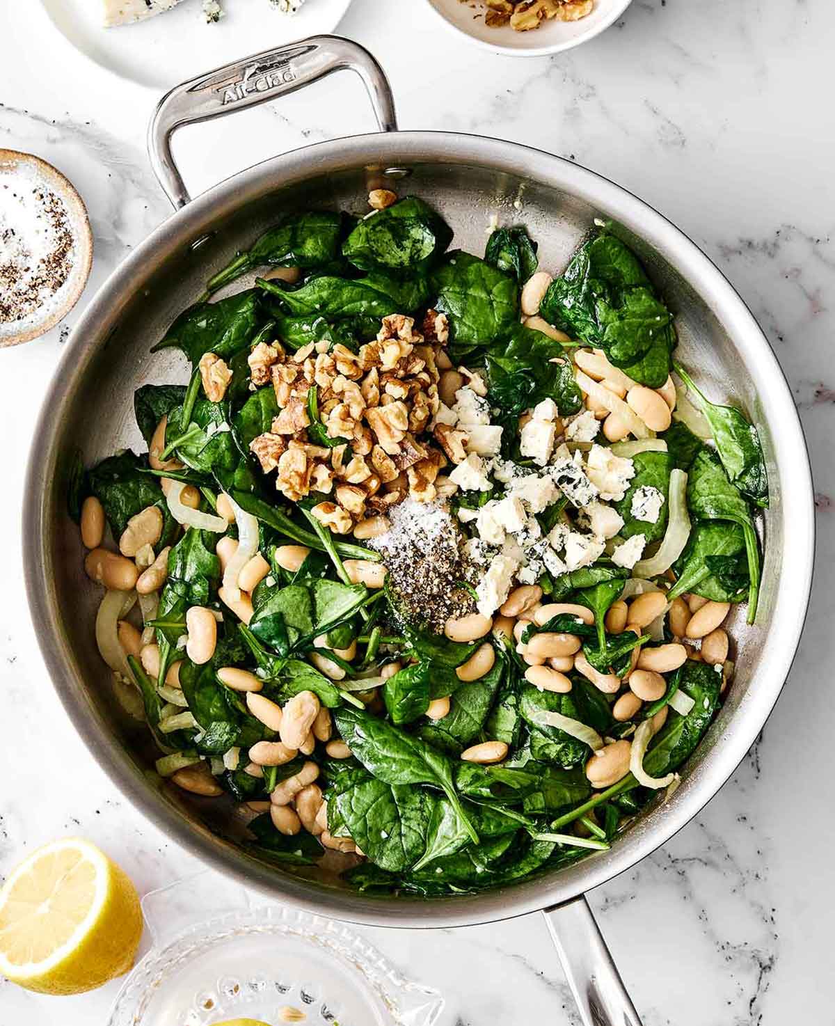 This warm spinach and white bean salad is my nudge to make more warm salads! It’s simple yet savory, healthy, and perfect for colder months. Step four of spinach and white bean salad: add the spinach.
