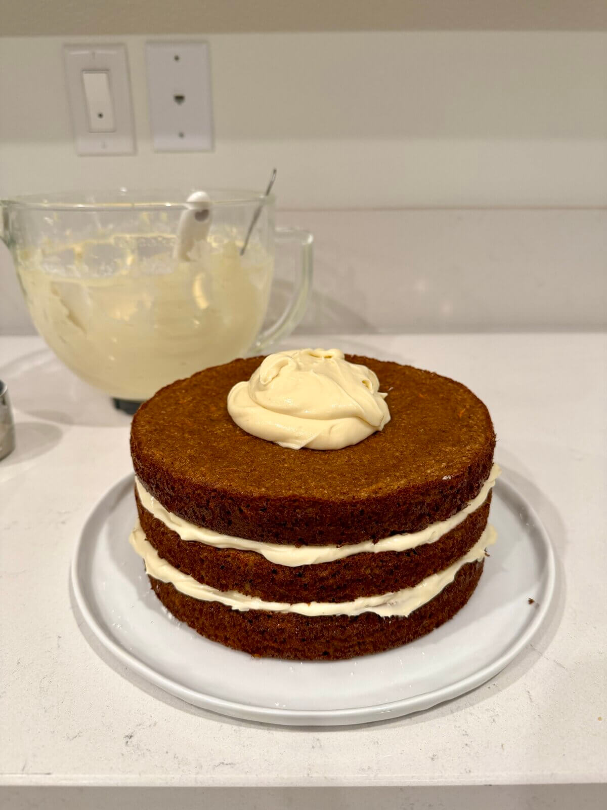 Frosting layers of the gluten-free carrot cake.