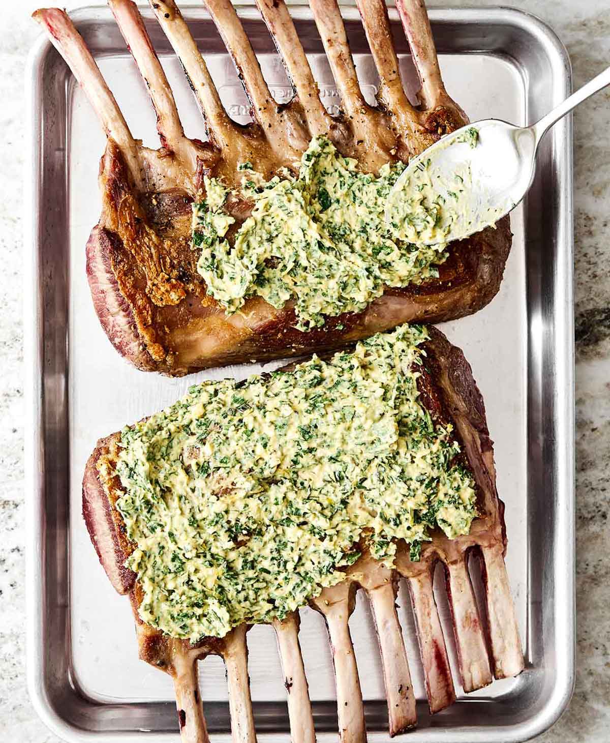 Step four of rack of lamb: spread herb butter on top.