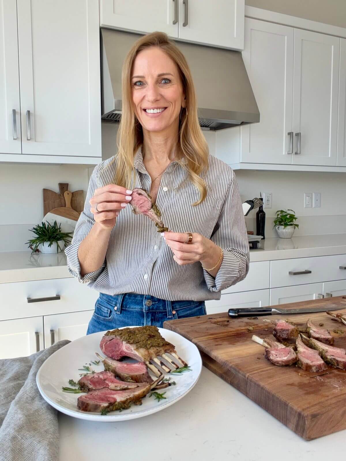 Lisa standing next to a platter of rack of lamb.