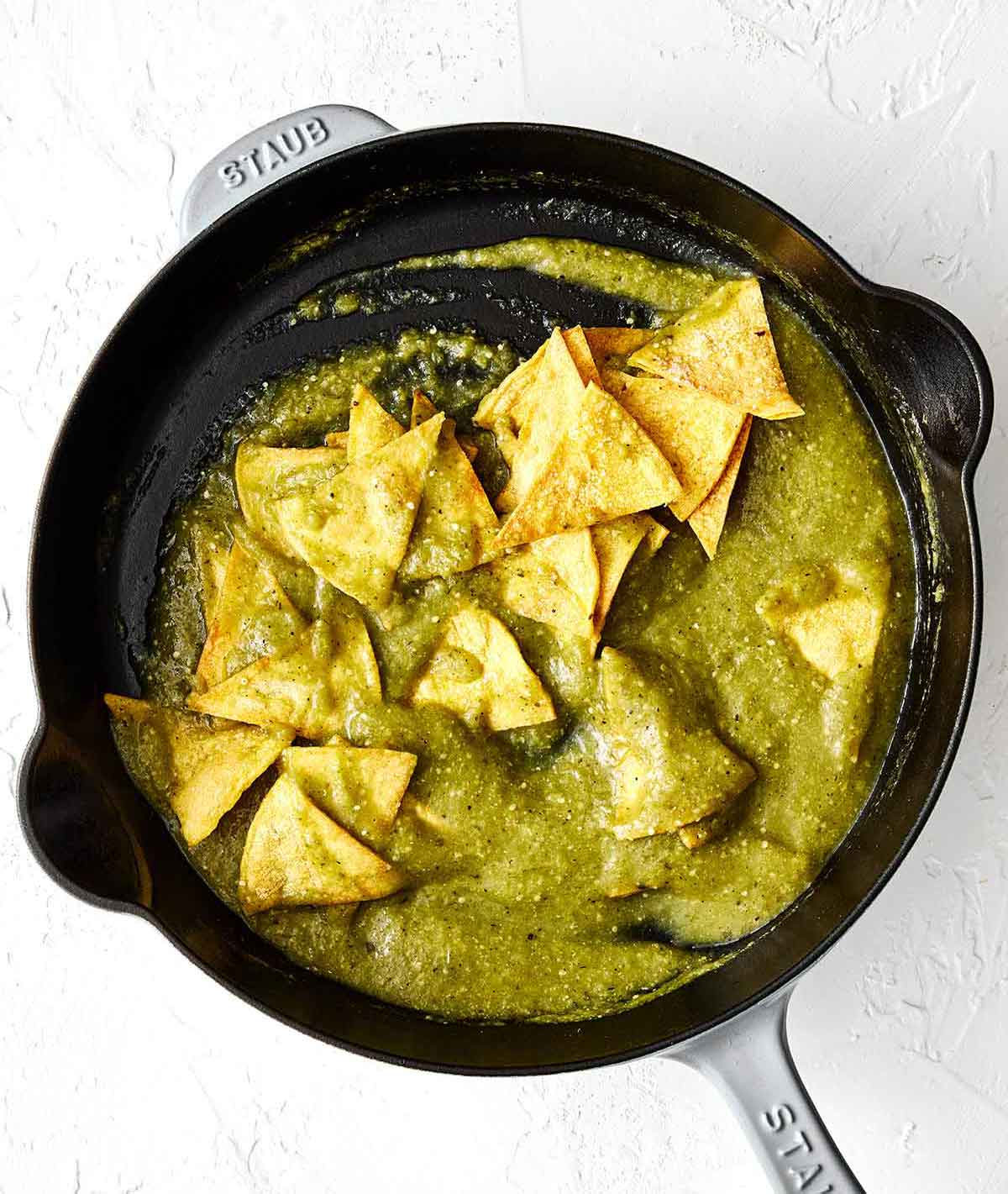 Step three chilaquiles: toss chips with salsa.