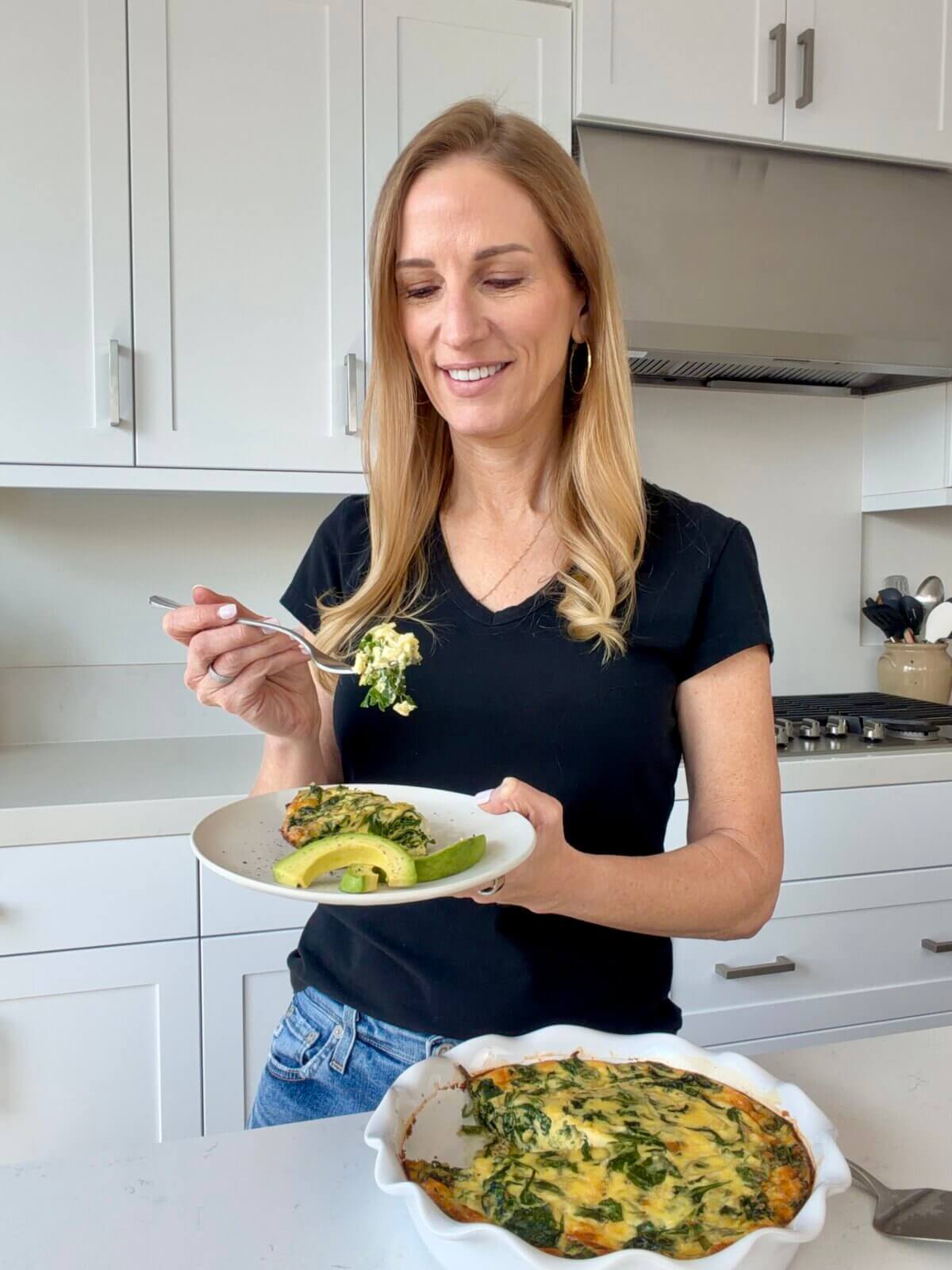 Lisa holding a plate with a slice of crustless quiche.