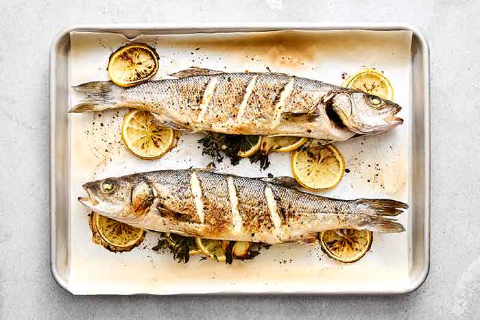 Roasted branzinos on a sheet pan.