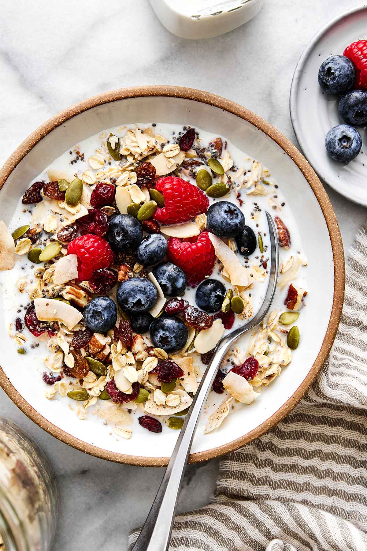 Homemade muesli in a bowl with fruits and milk.