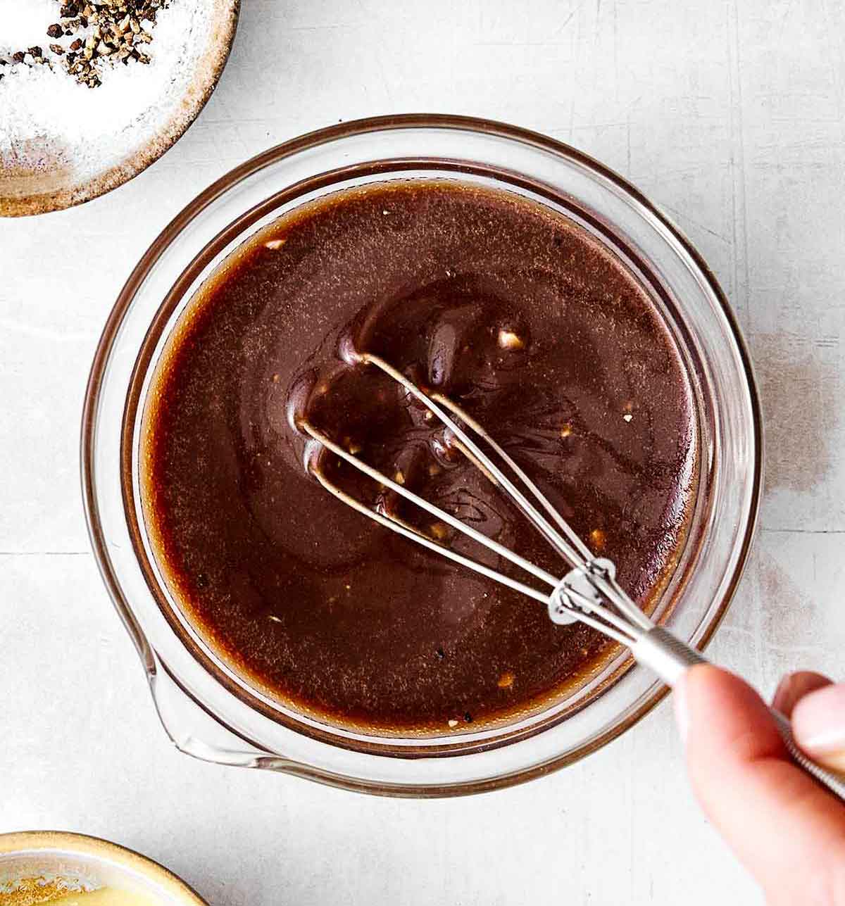 Whisking balsamic vinaigrette in a bowl.