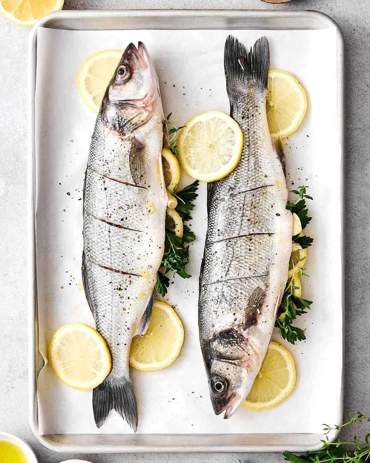 Seasoning whole branzinos before roasting.