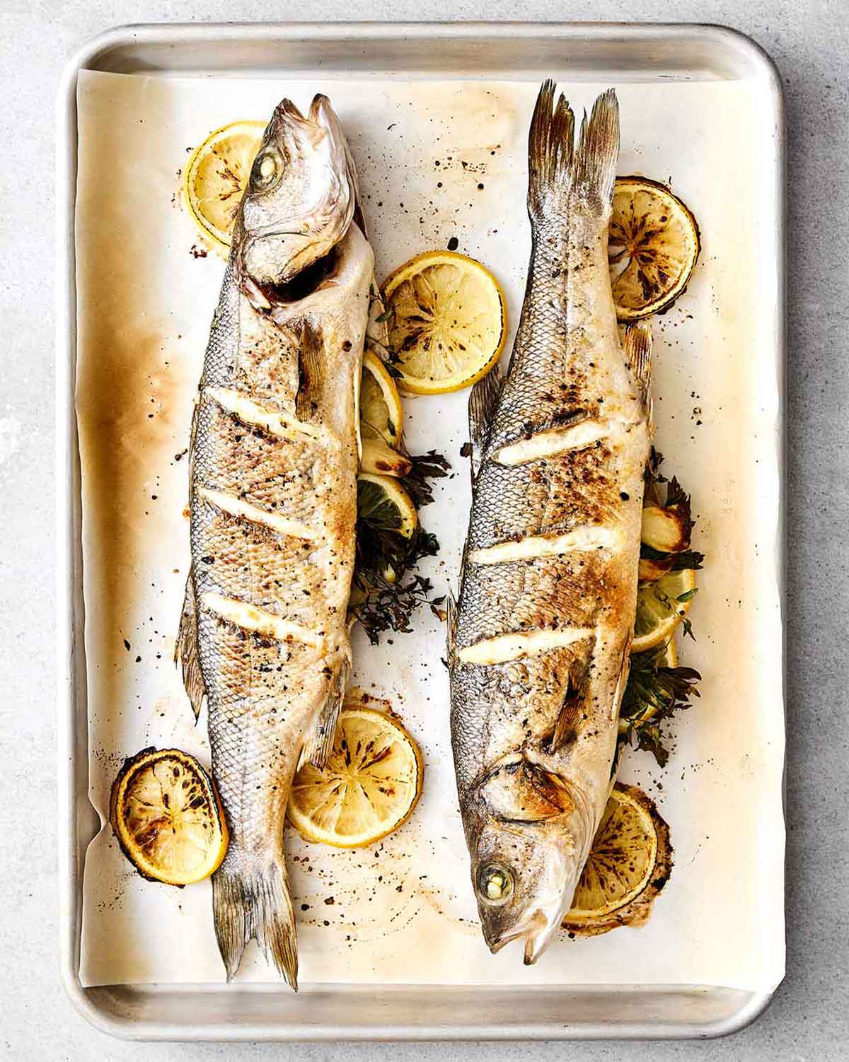 Roasted branzinos on a sheet pan.