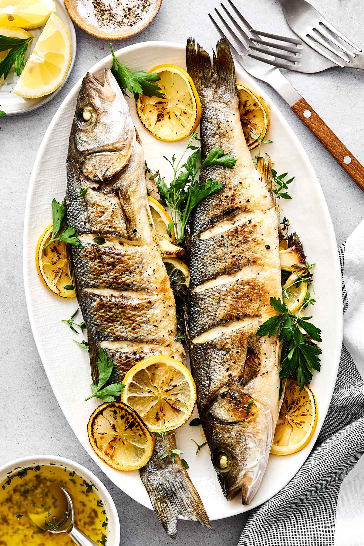 Whole roasted branzino on a plate.