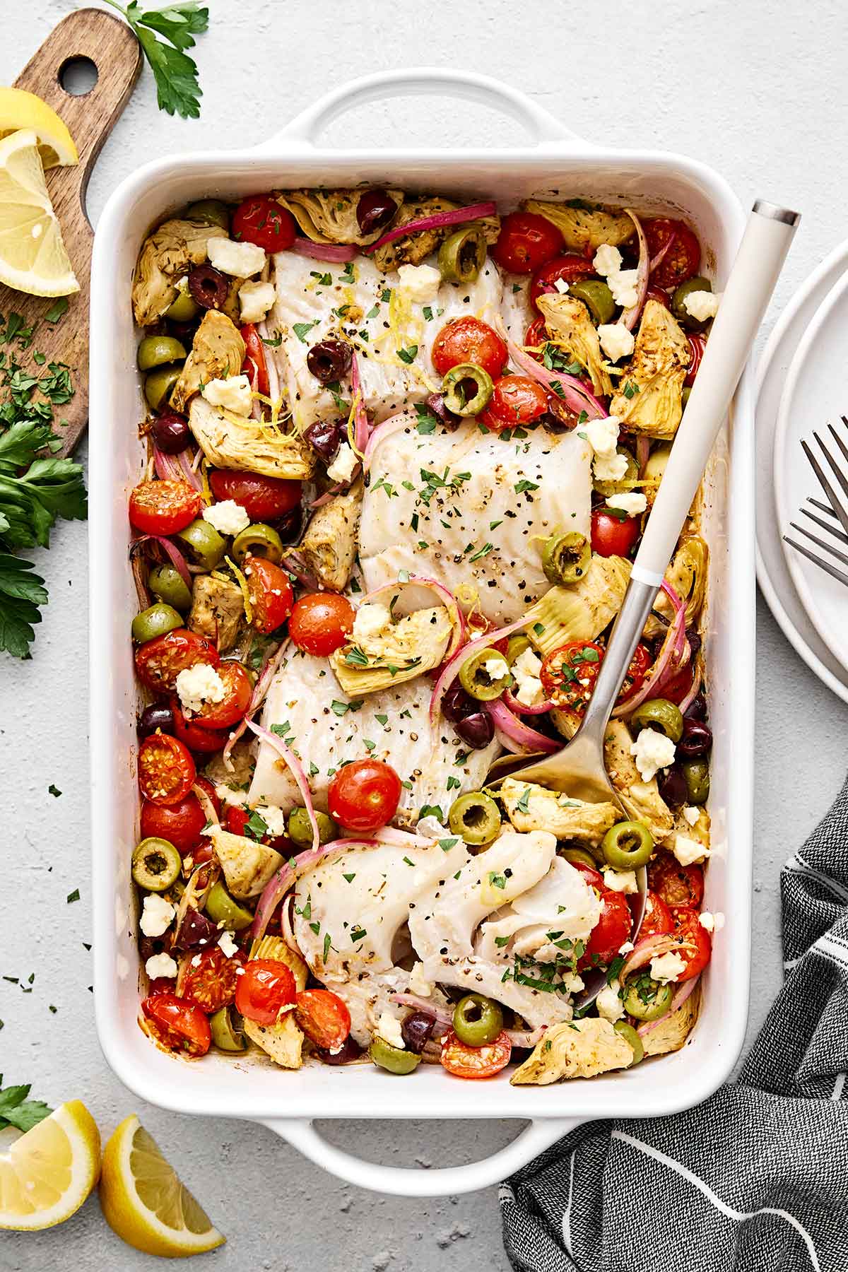 This Greek baked cod is the perfect all-in-one Mediterranean dinner! It's healthy, easy, and delicious! Greek baked cod with vegetables in a casserole pan.