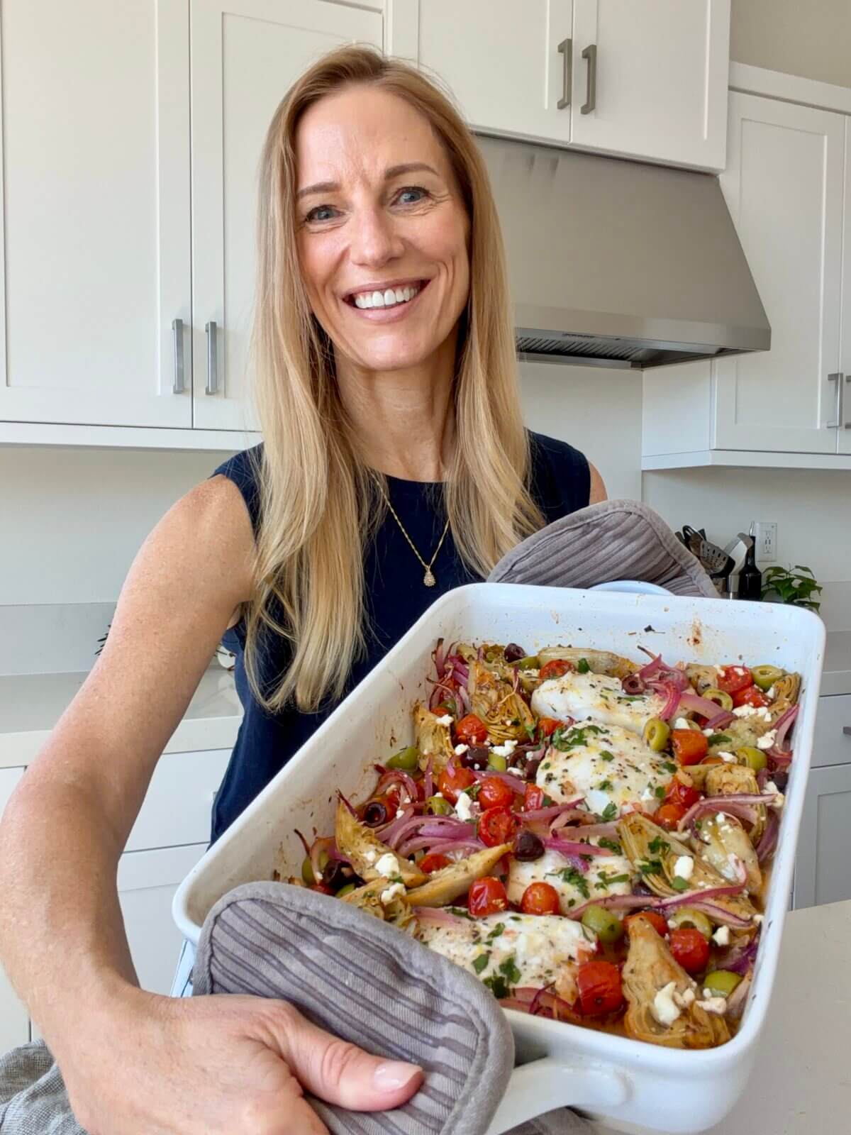 Lisa holding the baking dish of Greek Baked Cod.