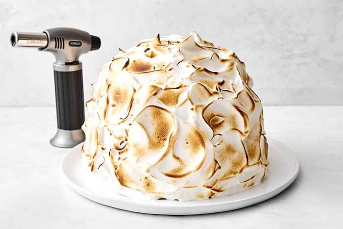 Torching the meringue on a baked Alaska.