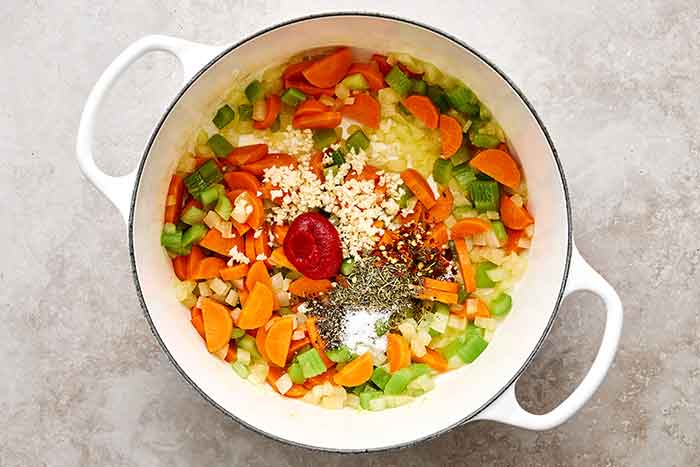 Cooking veggies with aromatics in a pot.