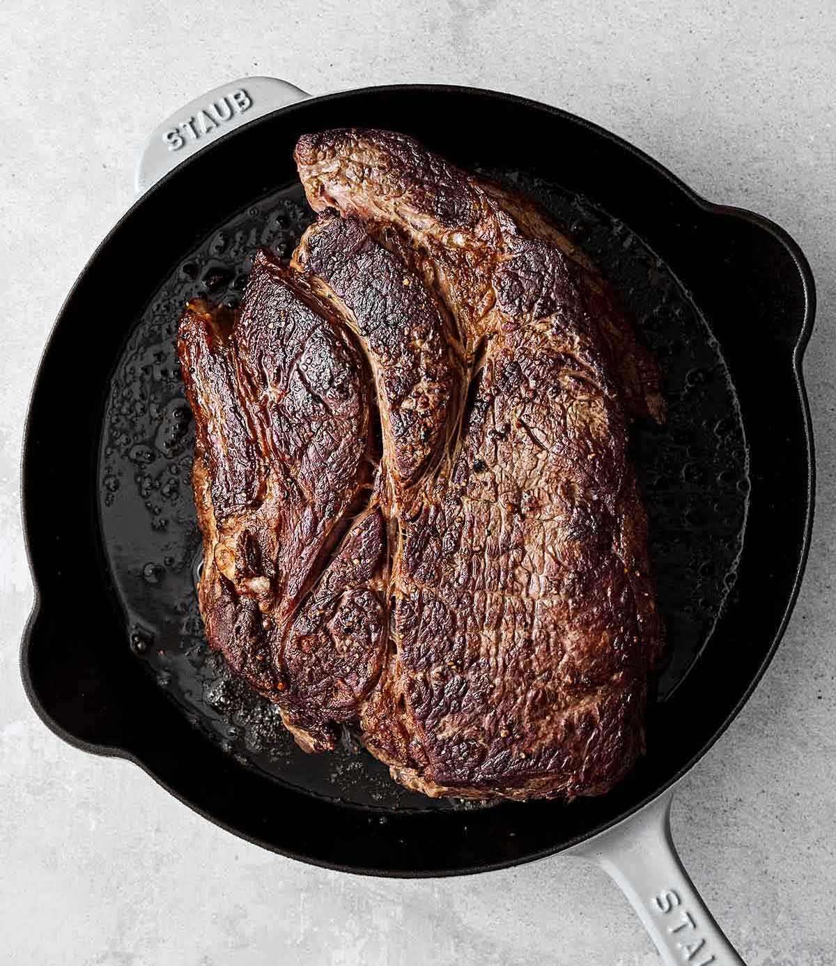 Searing chuck roast in a pan.