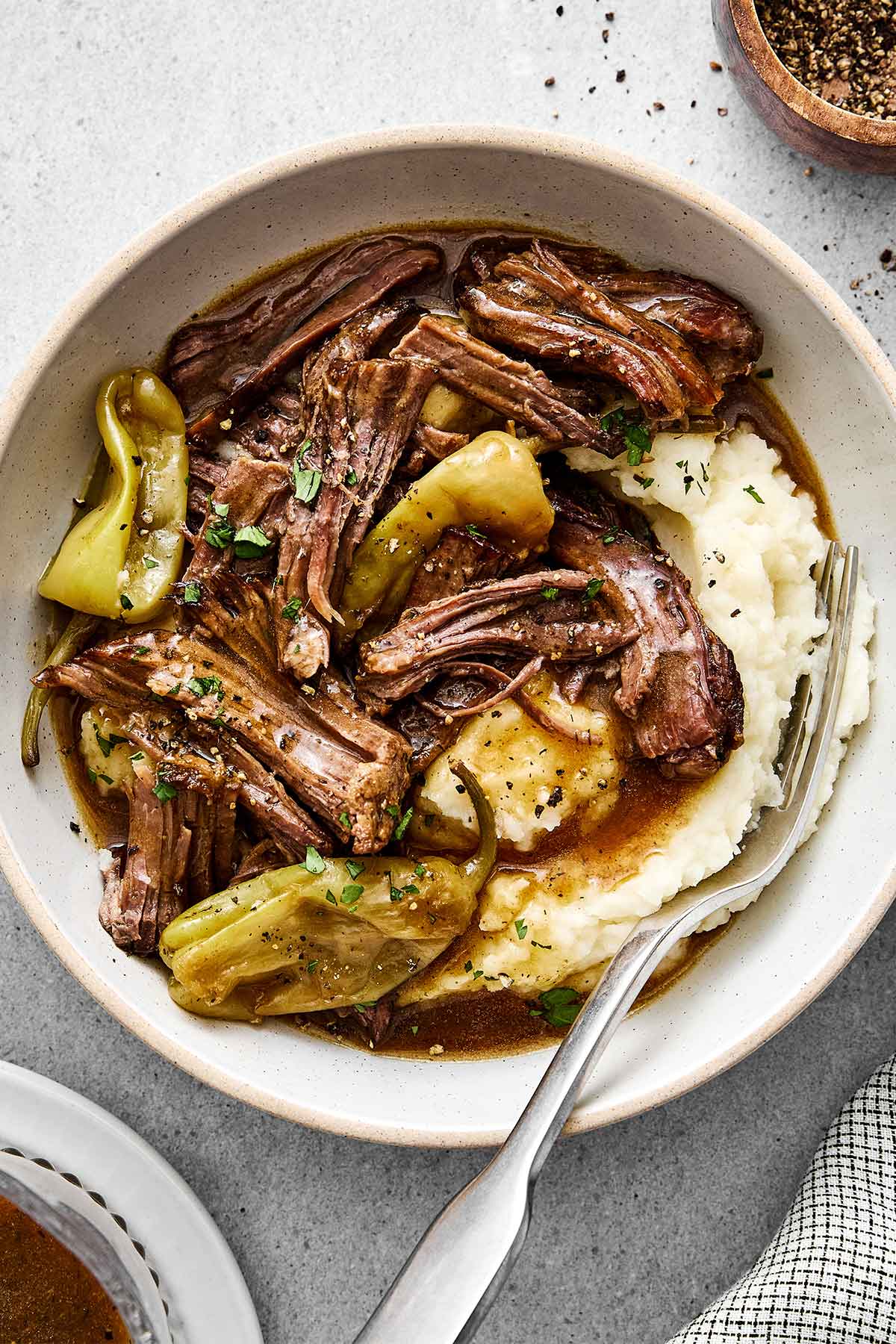 A bowl of Mississippi pot roast with mashed potatoes.