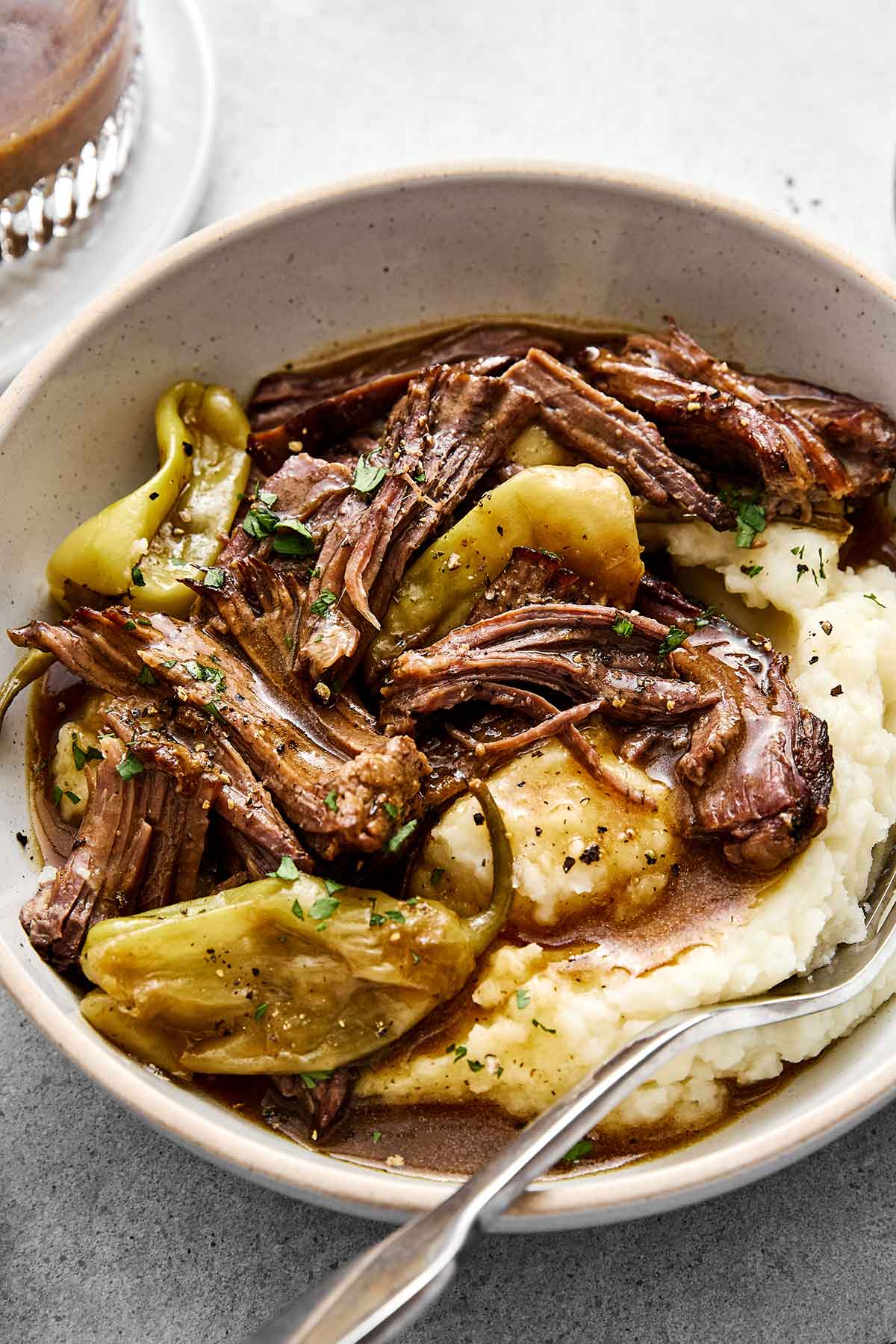 A bowl of Mississippi pot roast with mashed potatoes.
