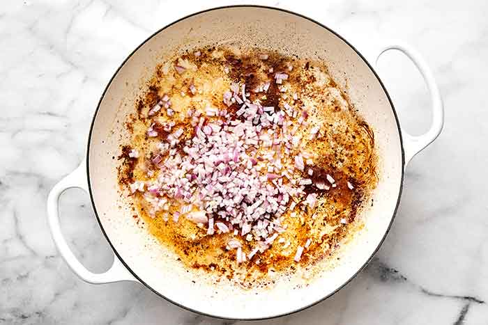 Cooking shallots in a pan.
