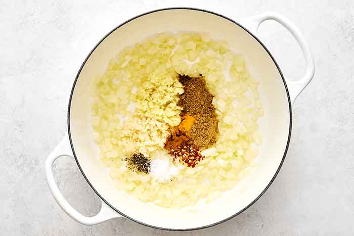 Cooking onions and spices in a pot.